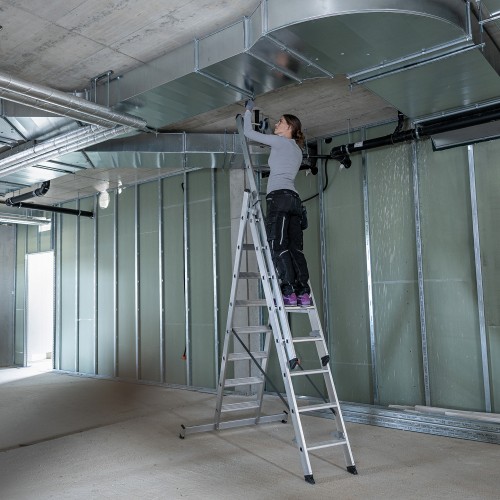 MUNK Stufen- Mehrzweckleiter mit Wandlaufrollen und Nivello® Traverse 3x7 Stufen